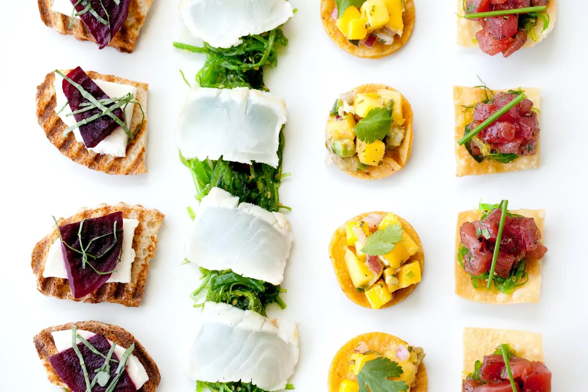 Rows of canapés: crostini, mozzarella and mango bites
